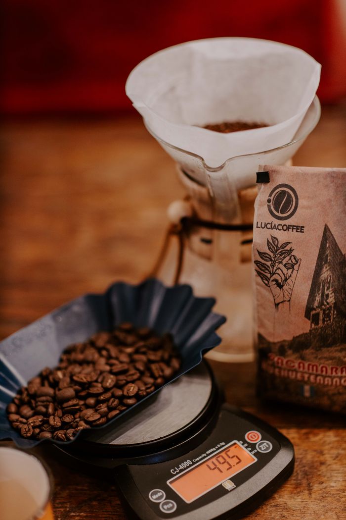services-01 Close-up of coffee beans on a scale with dripper and packaging in Huehuetenango, Guatemala.